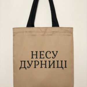 Шопер з принтом "Несу дурниці" - стильний та практичний аксесуар. Зображення показує шопер з ексклюзивним принтом "Несу дурниці". Ручки для носіння забезпечують зручність та комфорт, а місткий внутрішній відділ дозволяє зберігати необхідні речі під час прогулянок або походів по магазинах. Цей шопер відмінно підходить для щоденного використання та створить неповторний образ.